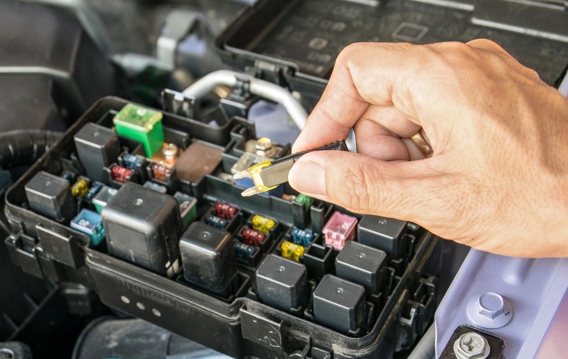 Auto mechanic checking a car fuses