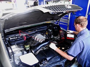 automotive technician performing mechanical service to vehicle